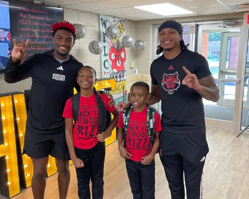  Two students are posing with two ASU football players