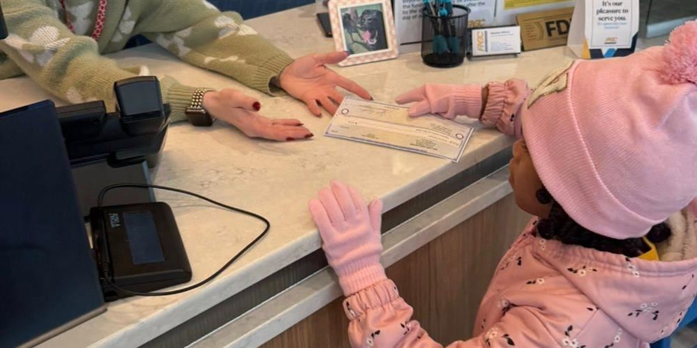  Student giving a lady her check to cash at the bank
