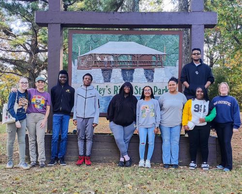  Smiling students and teachers in a line in front of the Crowley's Ridge Park sign